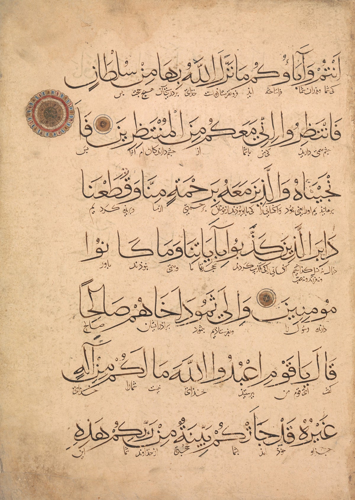 Qur'an Folio (Interlinear Script) — Seven lines of black script, each with fine writing beneath