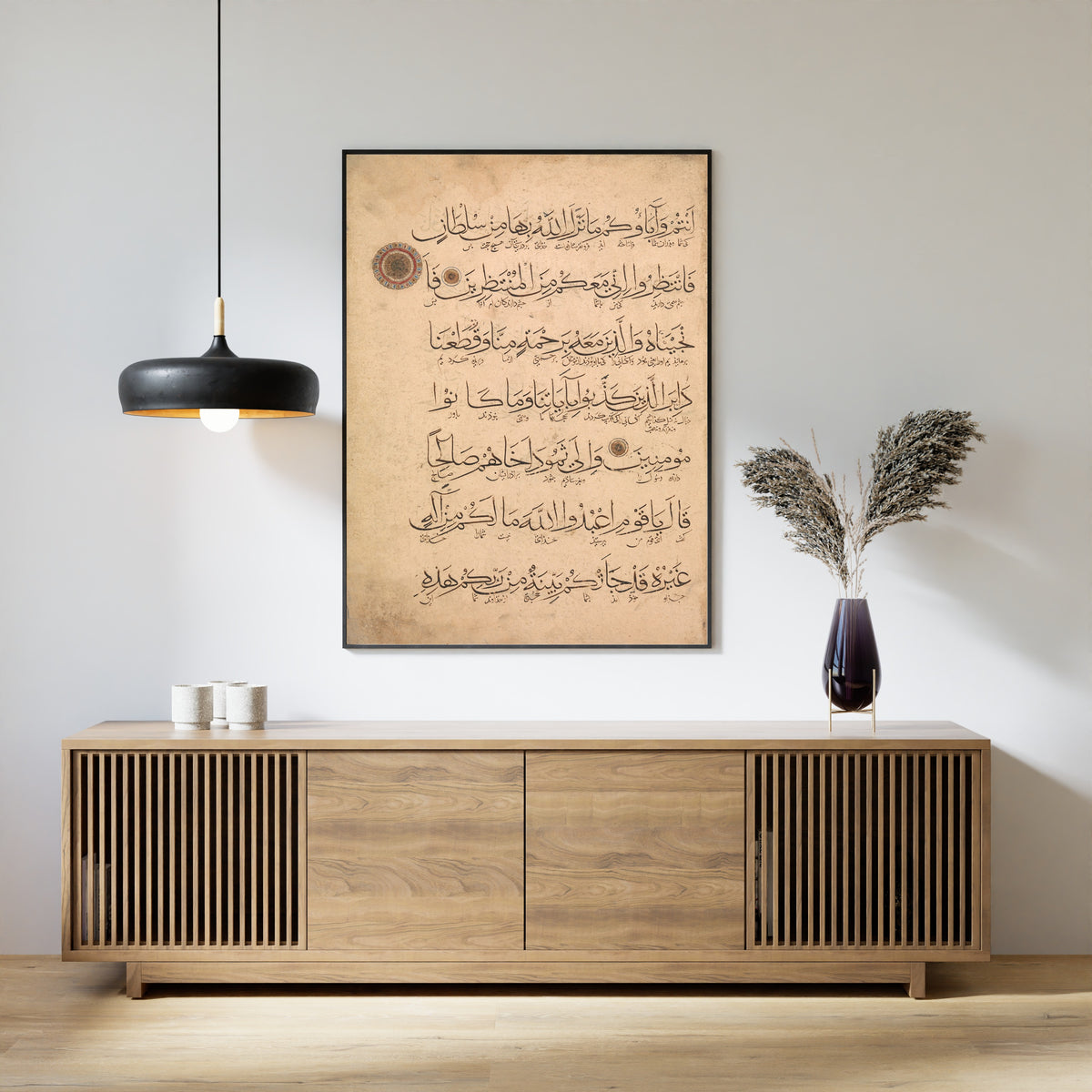 Framed art print of Qur'an Folio (Interlinear Script), above a slatted wood sideboard