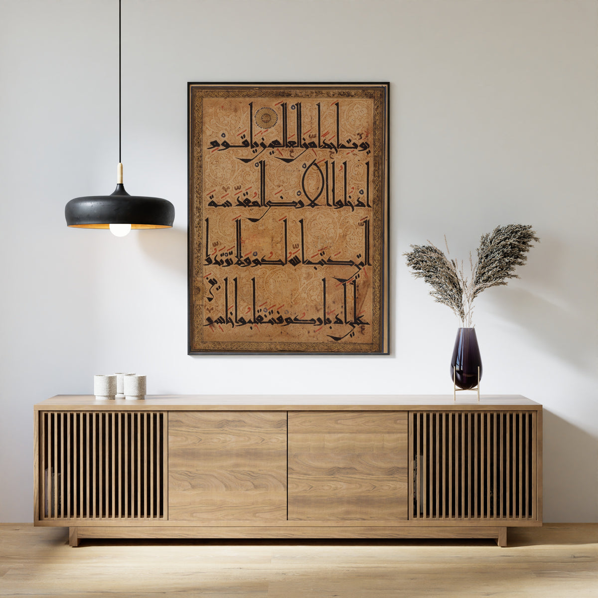 Framed art print of Qur'an Folio (Kufic on Scrolling Ground), above a slatted wood sideboard