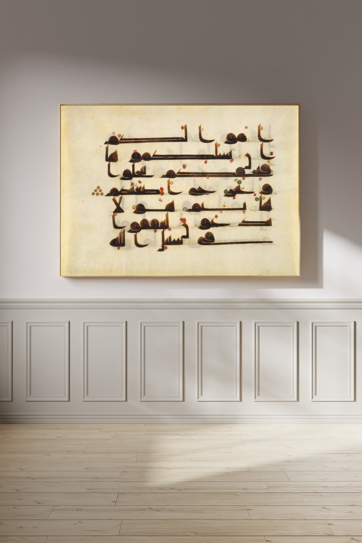 Framed art print of Qur'an Folio (Red and Green Dots on Parchment), on a panelled wall in afternoon light