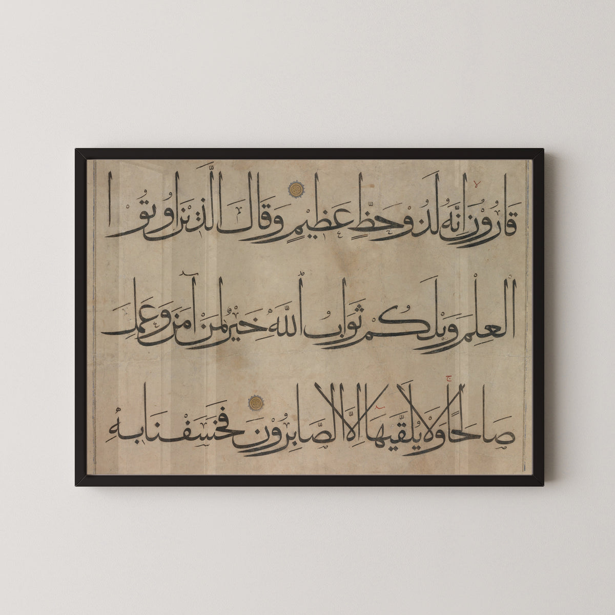 Framed art print of Qur'an Section (Three Lines) by `Umar Aqta', in a black frame on a pale wall