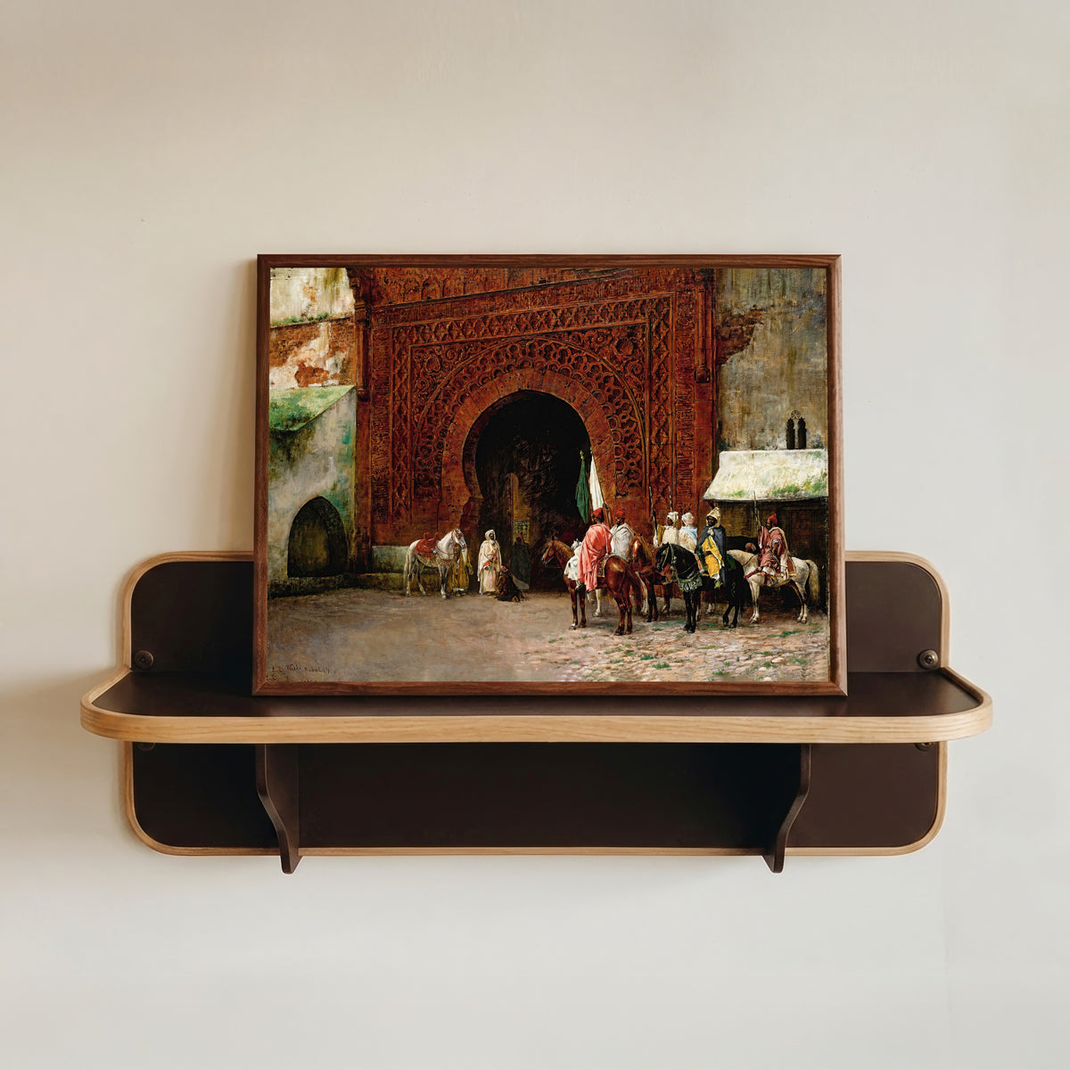 Framed art print of Rabat (The Red Gate) by Edwin Lord Weeks, in a dark wood frame resting on a wall shelf