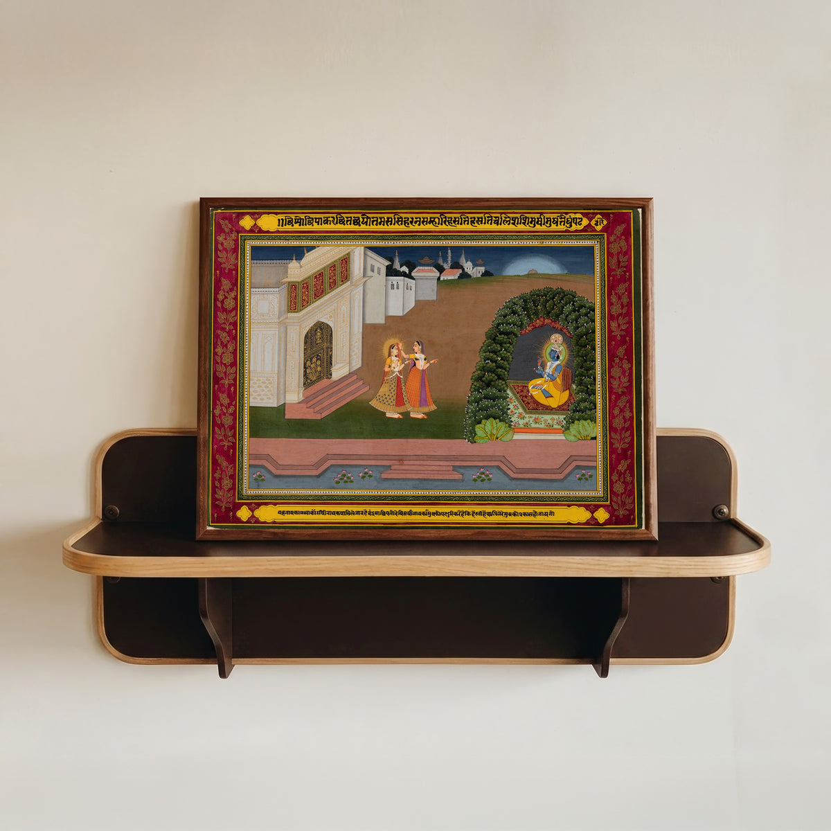 Framed art print of Radha’s Confidante Brings Her to Krishna, based on poetry of Bihari… by Jaipur school, in a dark wood frame resting on a wall shelf