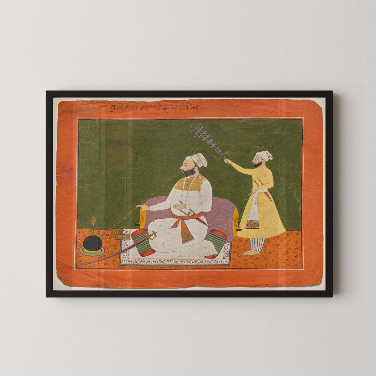 Framed art print of Raja Bikram Singh of Guler Smoking a Hookah by Pahari school, in a black frame on a pale wall