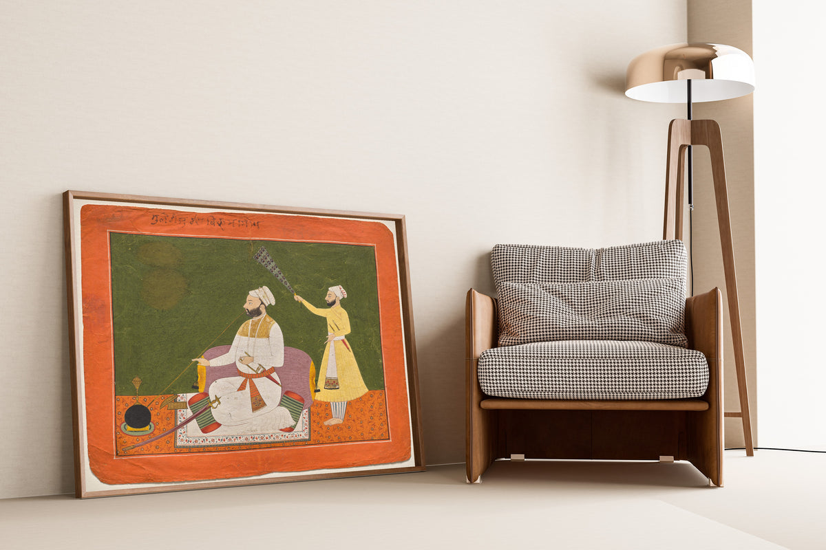 Framed art print of Raja Bikram Singh of Guler Smoking a Hookah by Pahari school, leaning against a wall beside an armchair and a floor lamp