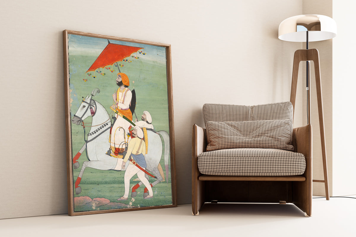 Framed art print of Raja Gulab Singh (1792–1857) of Jammu and Kashmir by Pahari school, leaning against a wall beside an armchair and a floor lamp