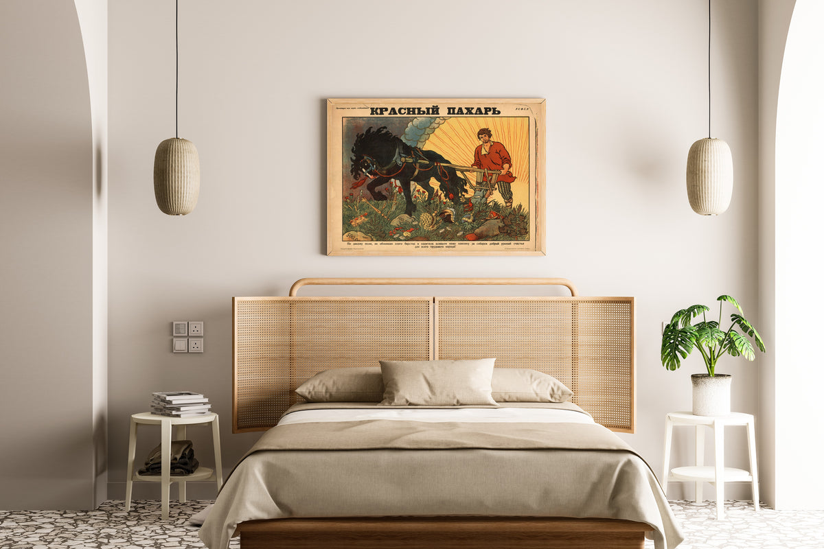 Framed art print of Red Ploughman by Boris Zvorykin, above a cane-headboard bed