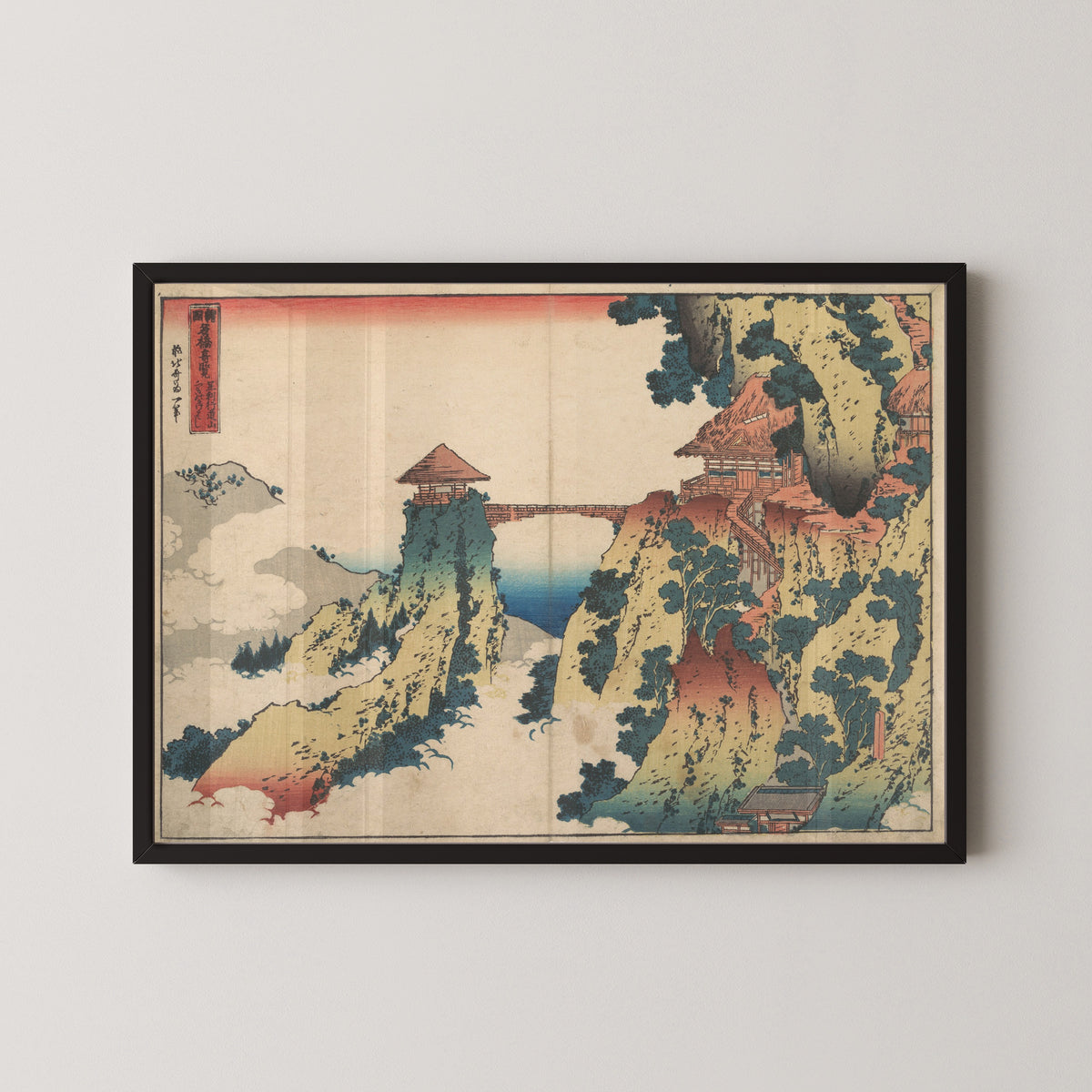 Framed art print of Remarkable Views of Bridges in Various Provinces: The Hanging-cloud Bridge at Mount… by Katsushika Hokusai, in a black frame on a pale wall