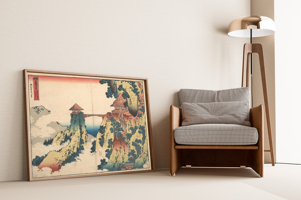 Framed art print of Remarkable Views of Bridges in Various Provinces: The… by Katsushika Hokusai, leaning against a wall beside an armchair and a floor lamp