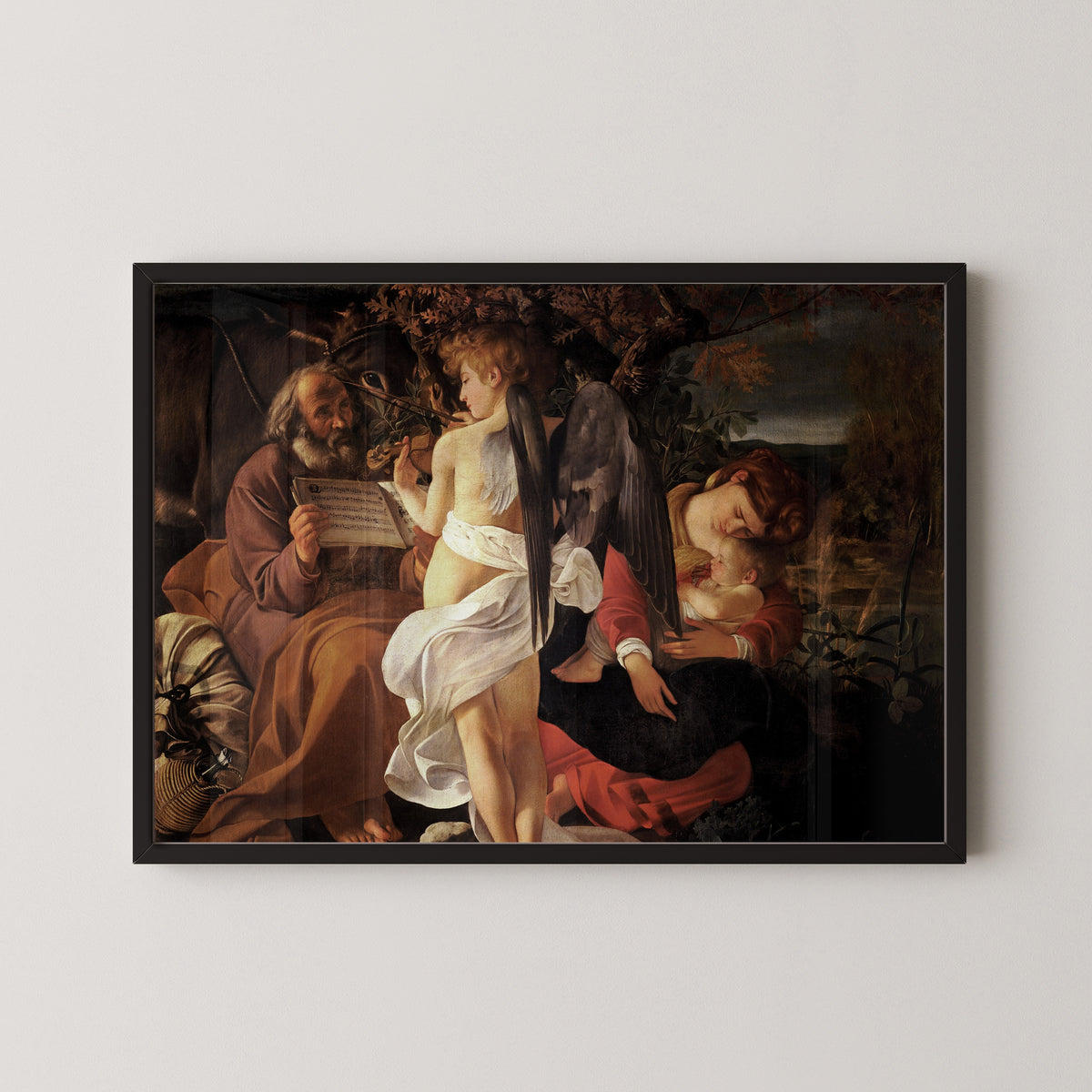 Framed art print of Rest on the Flight into Egypt by Caravaggio, in a black frame on a pale wall