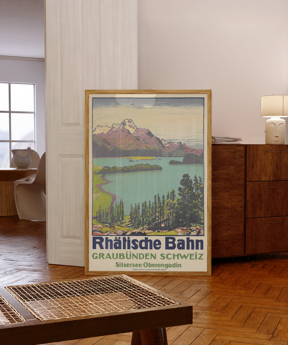 Framed art print of Rhätische Bahn: Graubünden Schweiz, Silsersee… by Emil Cardinaux, in a light wood frame leaning in a warm room with a parquet floor