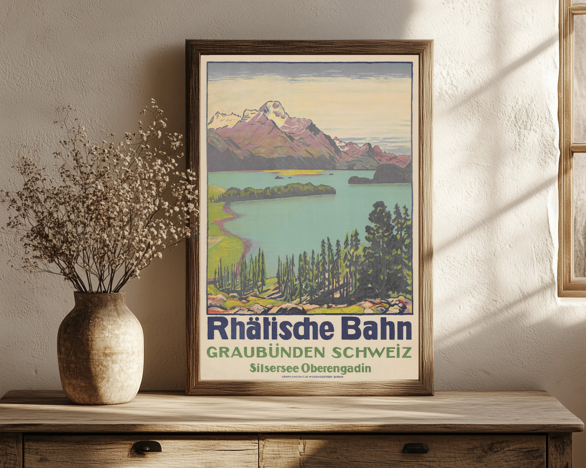 Framed art print of Rhätische Bahn: Graubünden Schweiz, Silsersee… by Emil Cardinaux, in a dark wood frame leaning on a rustic console beside dried flowers