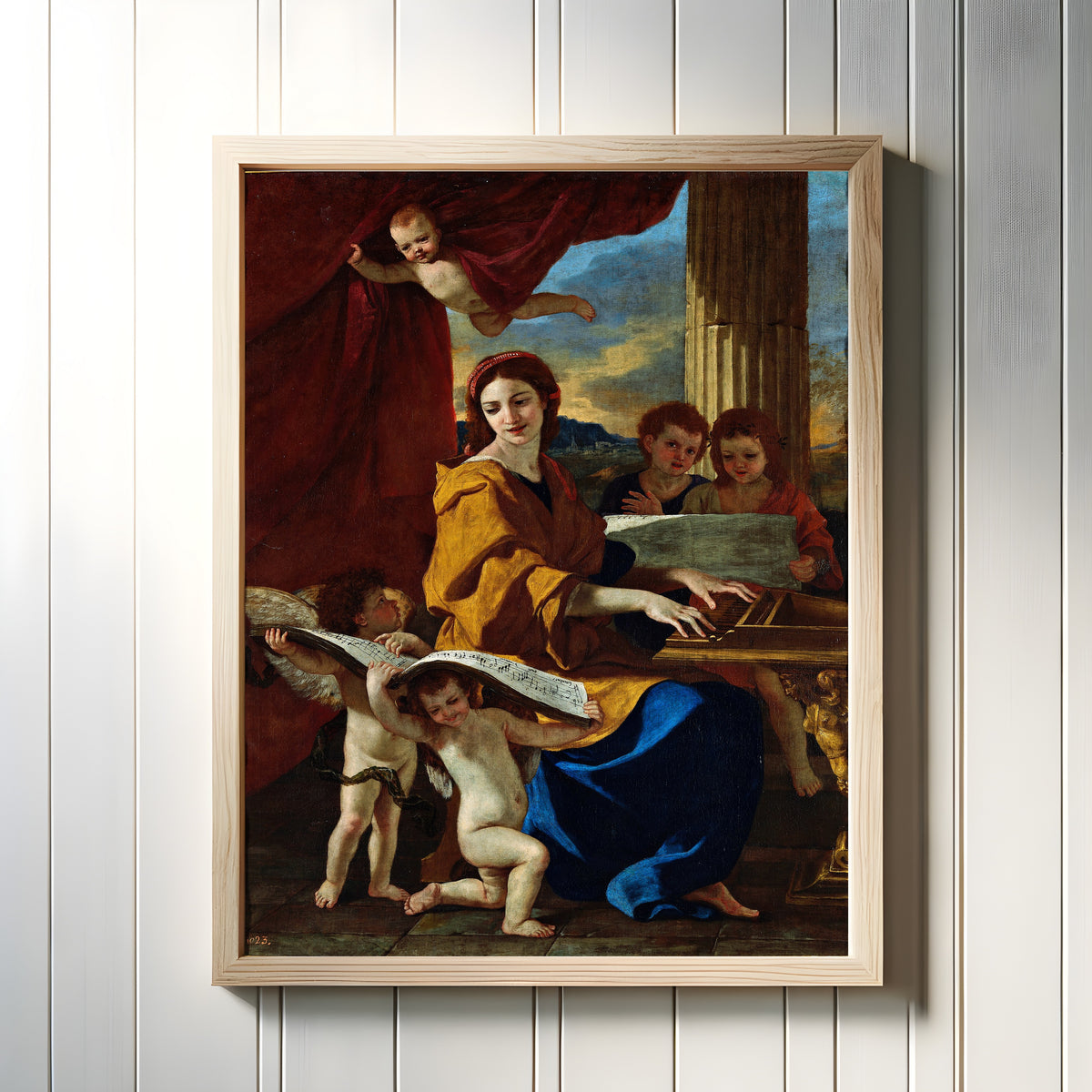 Framed art print of Saint Cecilia by Nicolas Poussin, in a light wood frame on a white panelled wall
