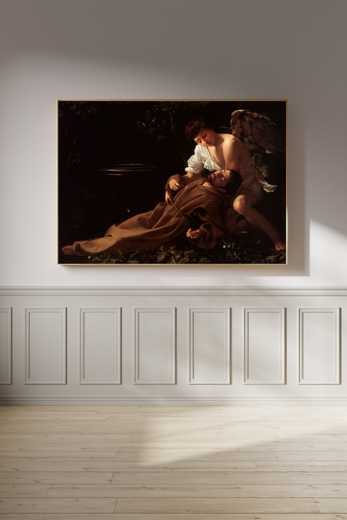 Framed art print of Saint Francis of Assisi in Ecstasy by Caravaggio, on a panelled wall in afternoon light