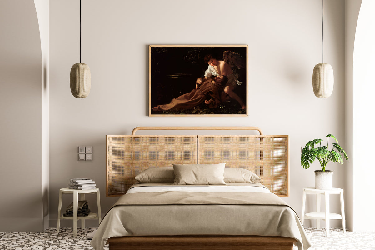 Framed art print of Saint Francis of Assisi in Ecstasy by Caravaggio, above a cane-headboard bed