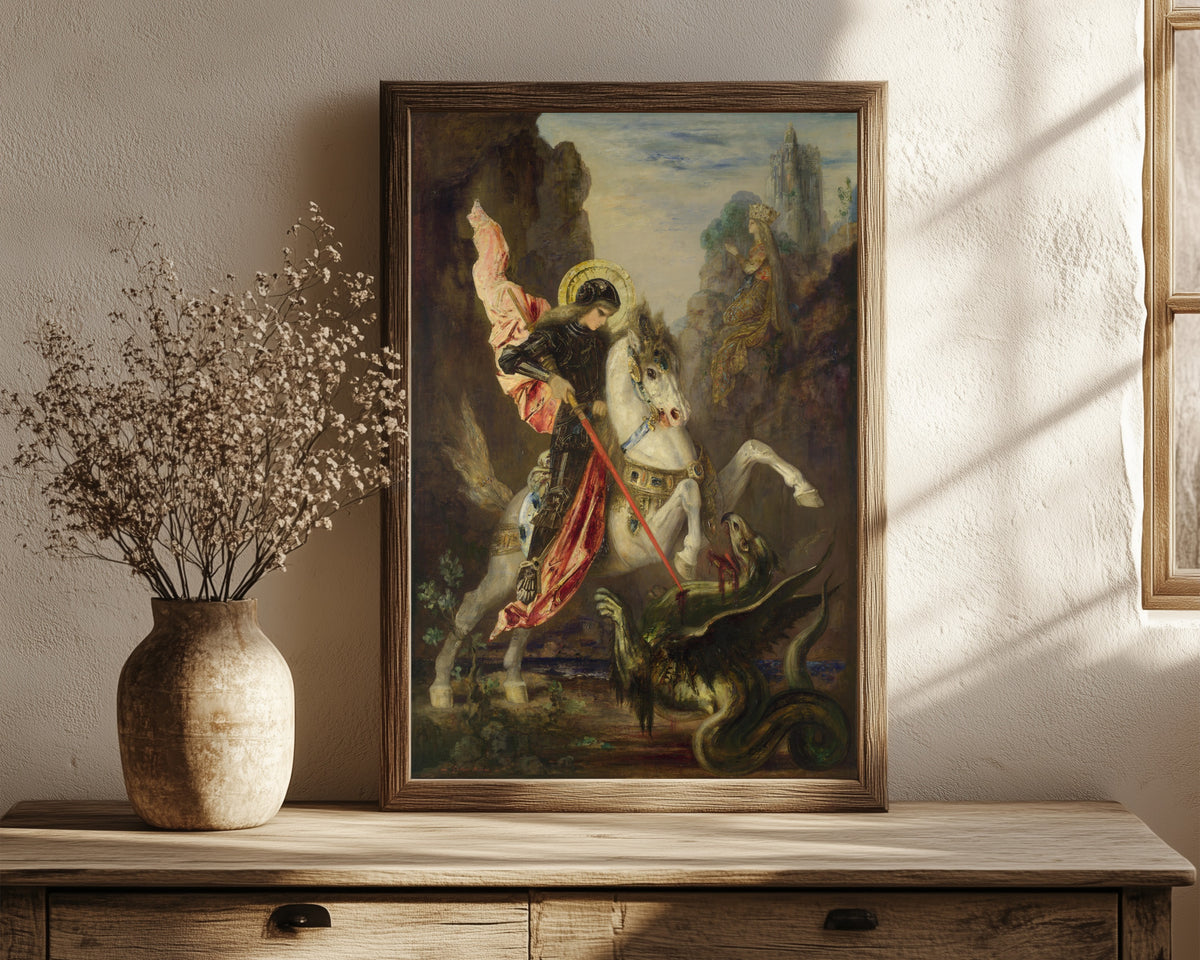 Framed art print of Saint George and the Dragon by Gustave Moreau, in a dark wood frame leaning on a rustic console beside dried flowers