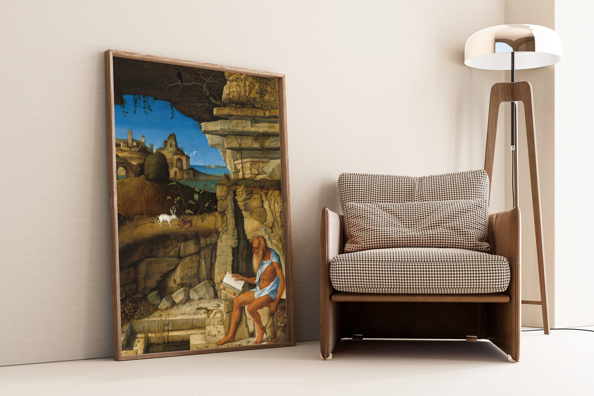 Framed art print of Saint Jerome Reading by Giovanni Bellini, leaning against a wall beside an armchair and a floor lamp