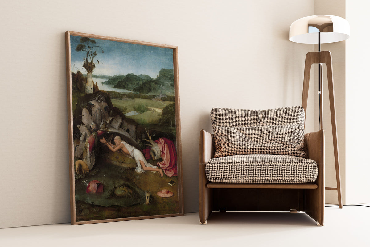 Framed art print of Saint Jerome by Hieronymus Bosch, leaning against a wall beside an armchair and a floor lamp