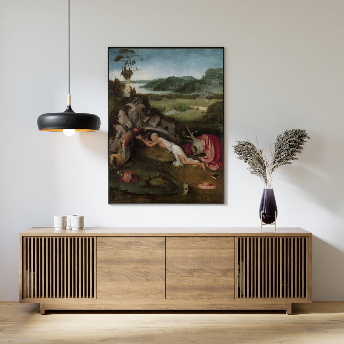 Framed art print of Saint Jerome by Hieronymus Bosch, above a slatted wood sideboard