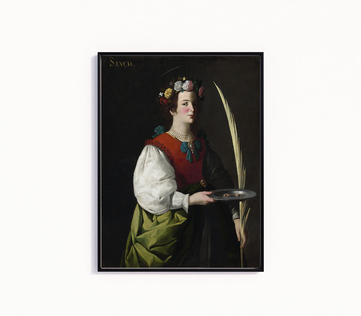 Framed art print of Saint Lucy by Francisco de Zurbarán, in a slim black frame on a plain white wall
