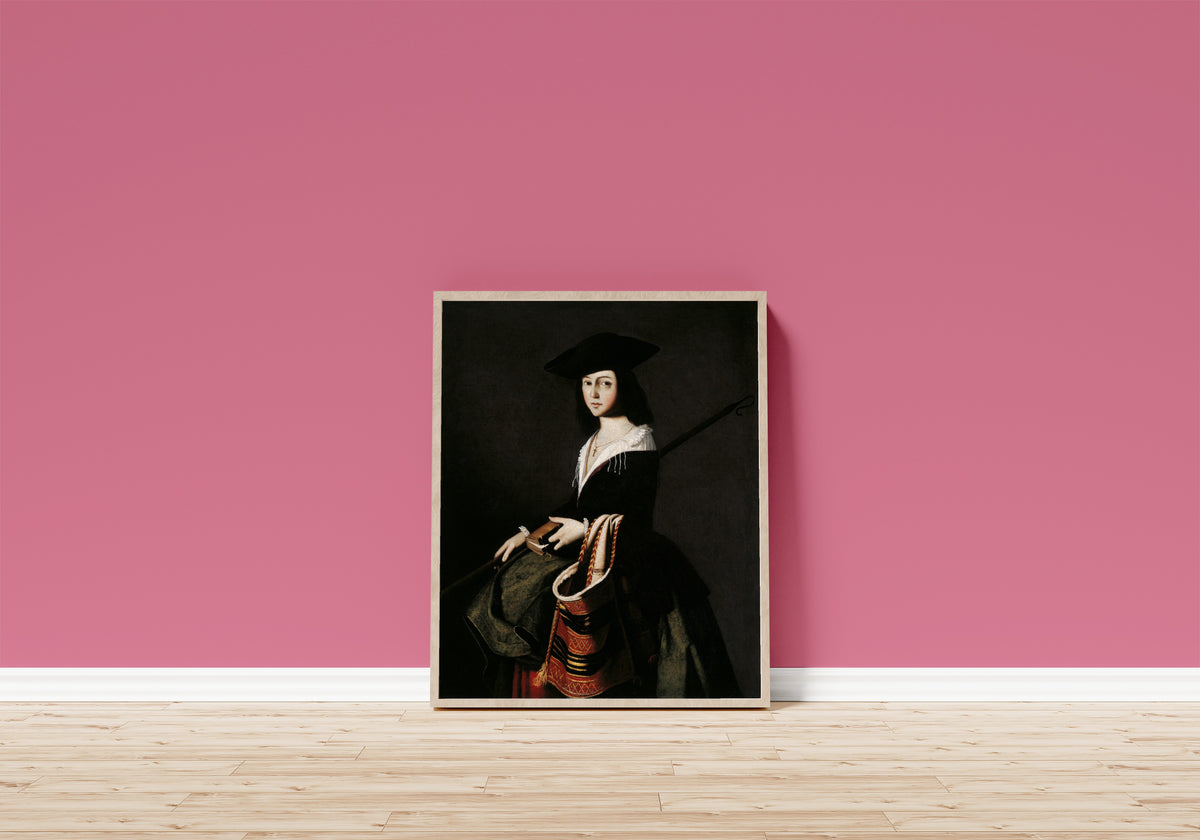 Framed art print of Saint Marina by Francisco de Zurbarán, in a light wood frame leaning on a pink wall above a wooden floor