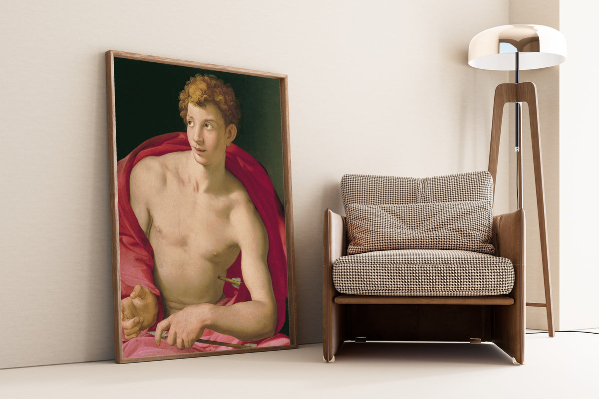 Framed art print of Saint Sebastian by Bronzino, leaning against a wall beside an armchair and a floor lamp