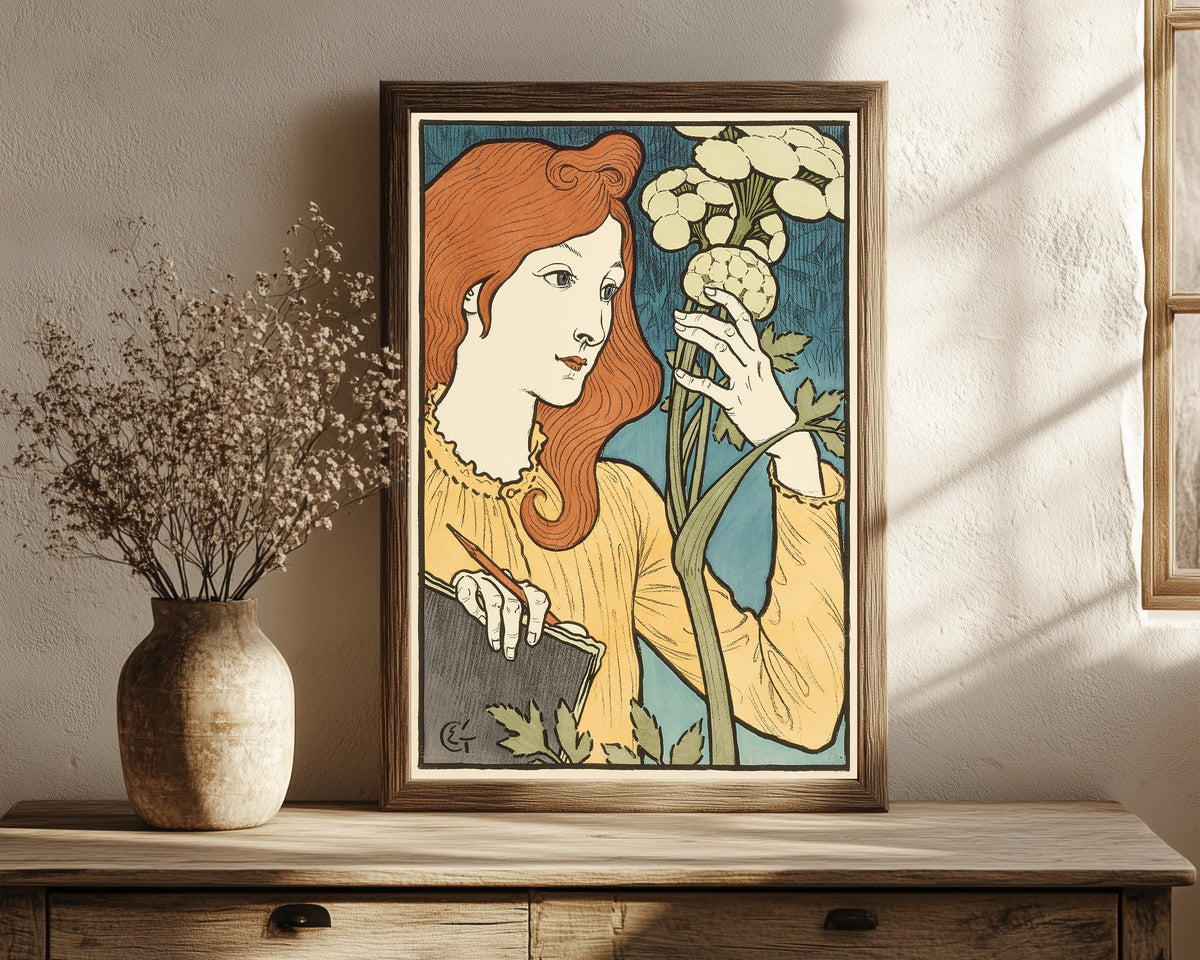 Framed art print of Salon des Cent by Eugène Grasset, in a dark wood frame leaning on a rustic console beside dried flowers