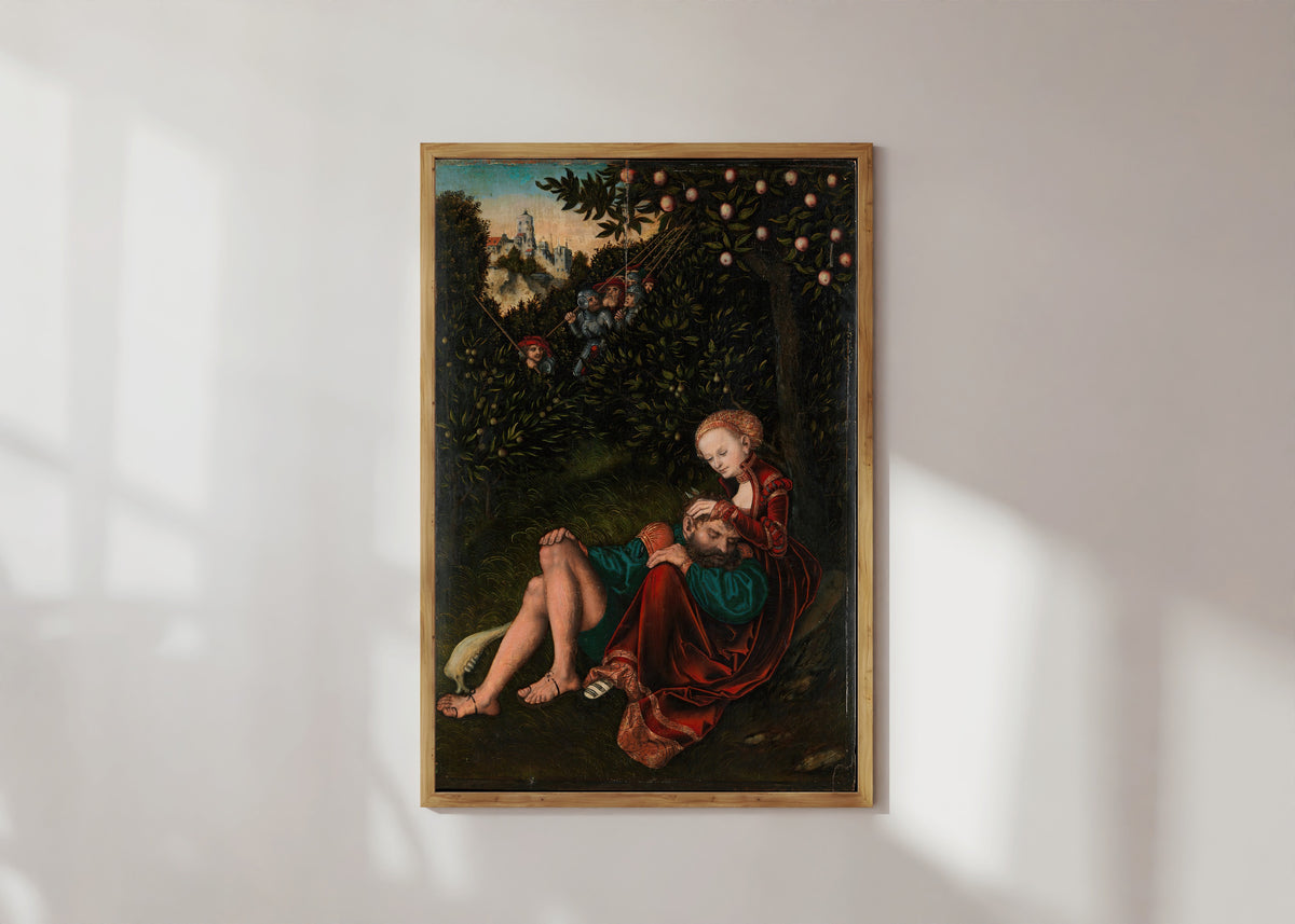 Framed art print of Samson and Delilah by Lucas Cranach the Elder, in a light wood frame on a sunlit white wall