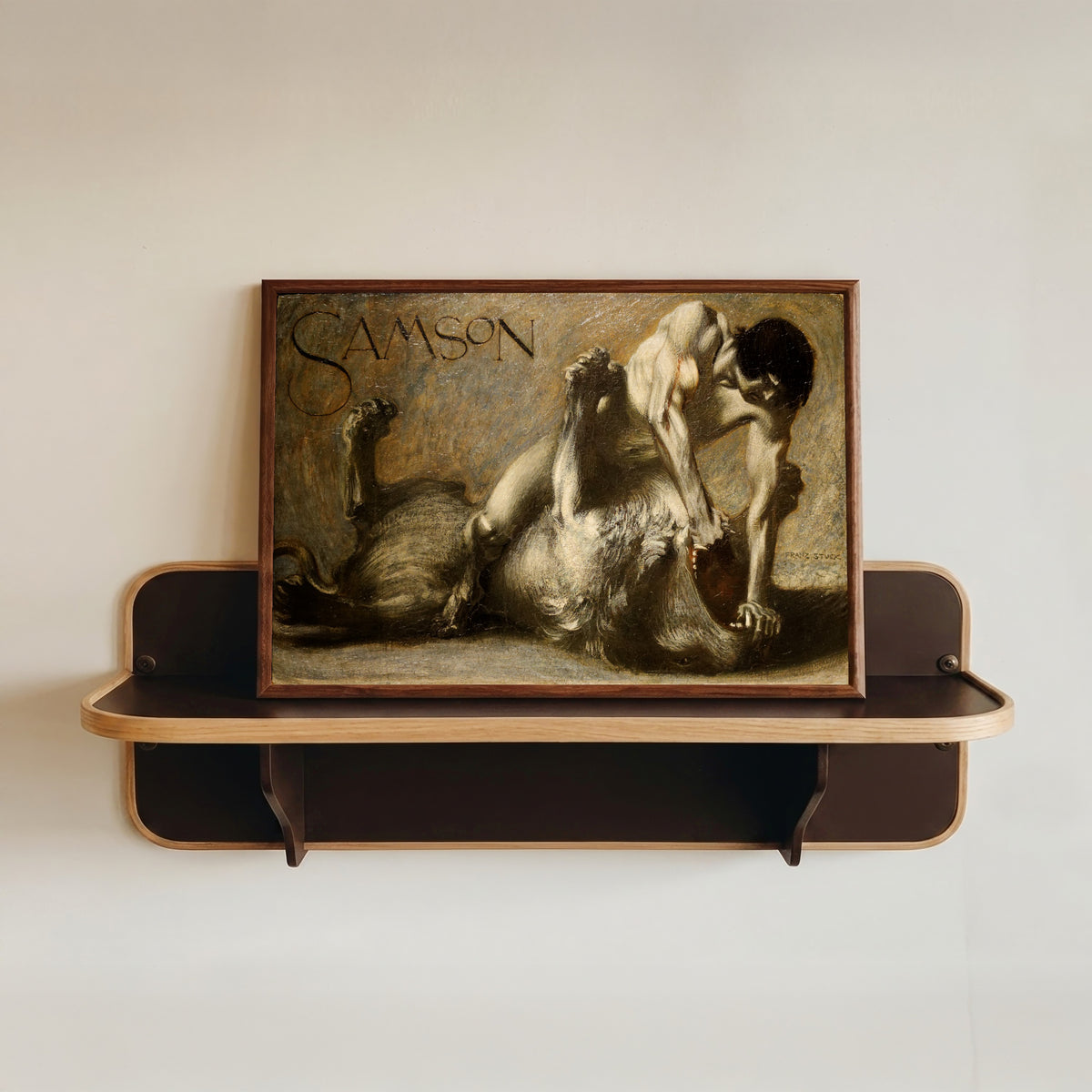 Framed art print of Samson by Franz von Stuck, in a dark wood frame resting on a wall shelf