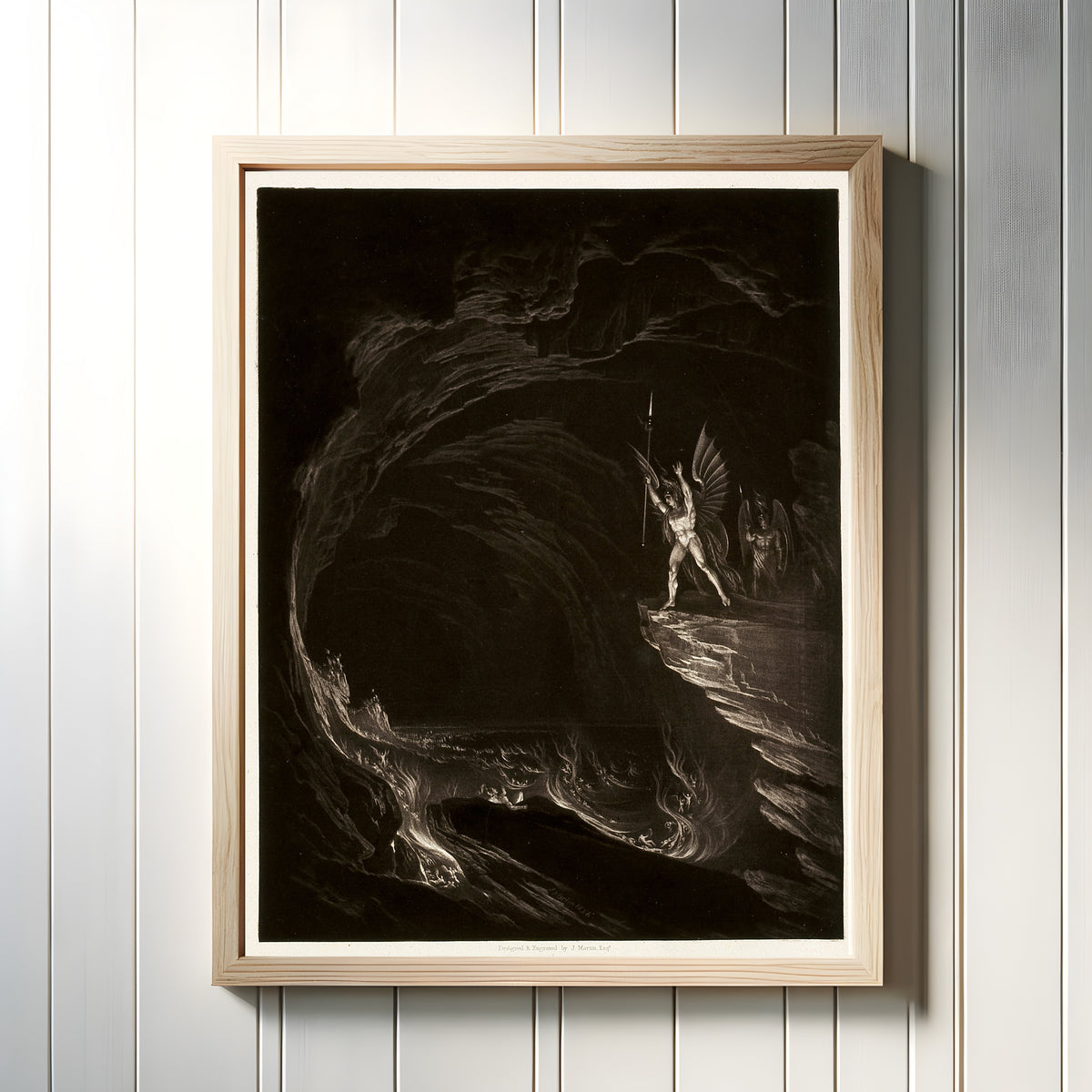 Framed art print of Satan Arousing the Fallen Angels, from Paradise Lost, Book 1 by John Martin, in a light wood frame on a white panelled wall