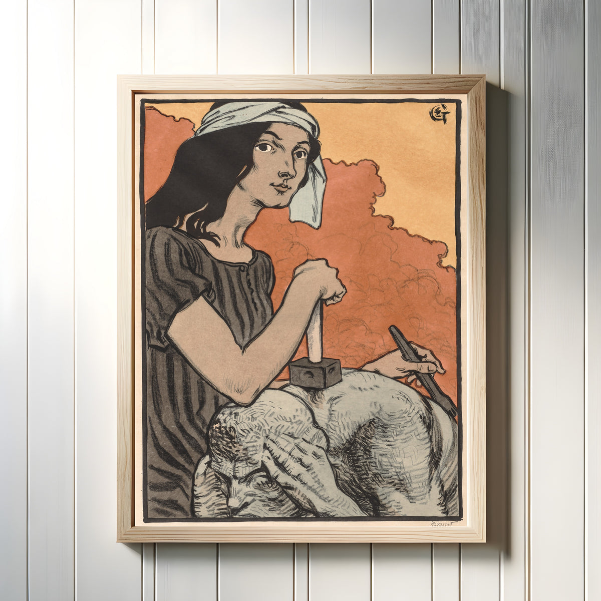 Framed art print of Sculptress by Eugène Grasset, in a light wood frame on a white panelled wall
