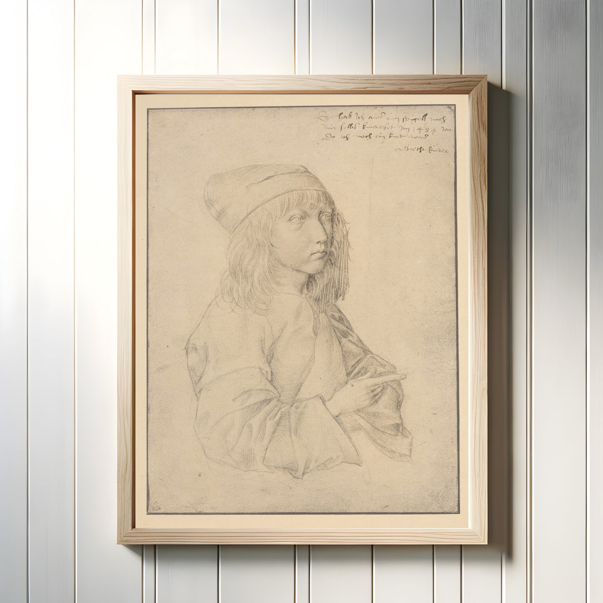Framed art print of Self-Portrait at Thirteen by Albrecht Dürer, in a light wood frame on a white panelled wall
