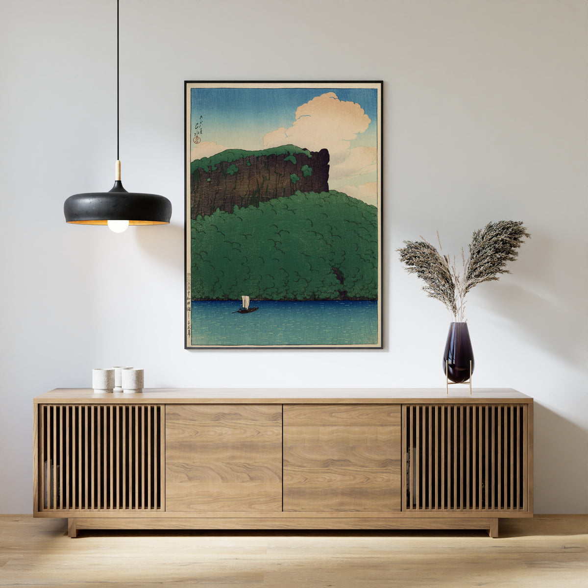 Framed art print of Senjo Cliff, Lake Towada by Kawase Hasui, above a slatted wood sideboard