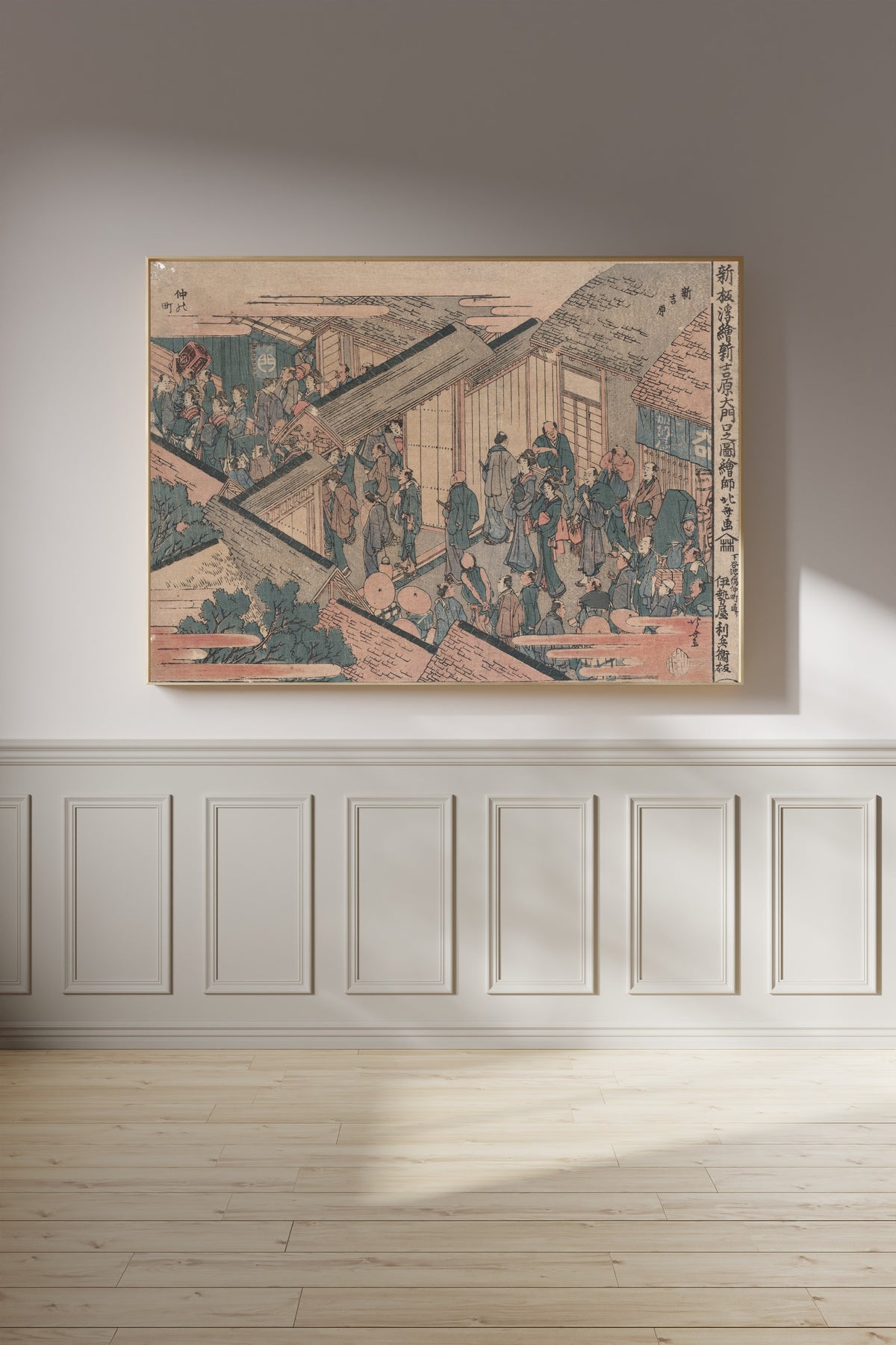 Framed art print of Shinpan ukie shin yoshiwara ōmonuchi no zu by Katsushika Hokusai, on a panelled wall in afternoon light