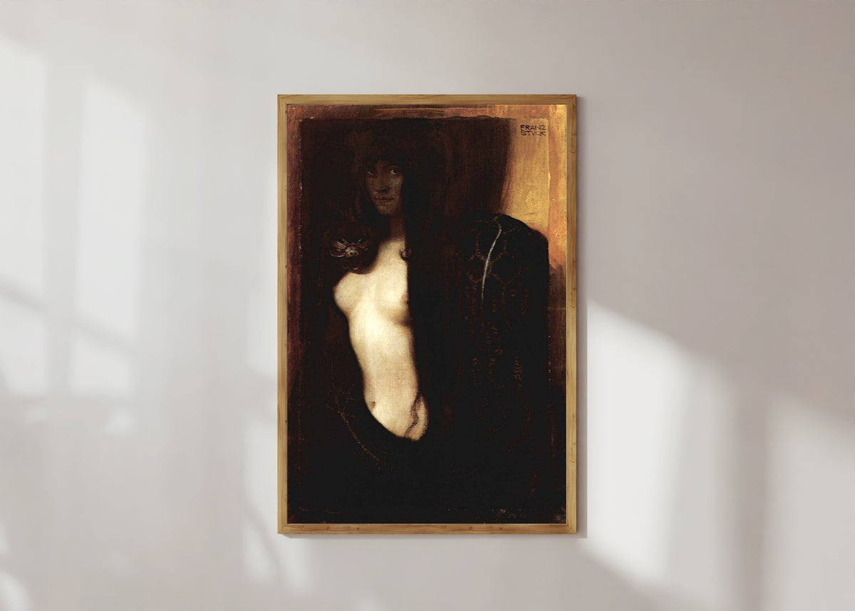 Framed art print of Sin (Die Sünde) by Franz von Stuck, in a light wood frame on a sunlit white wall