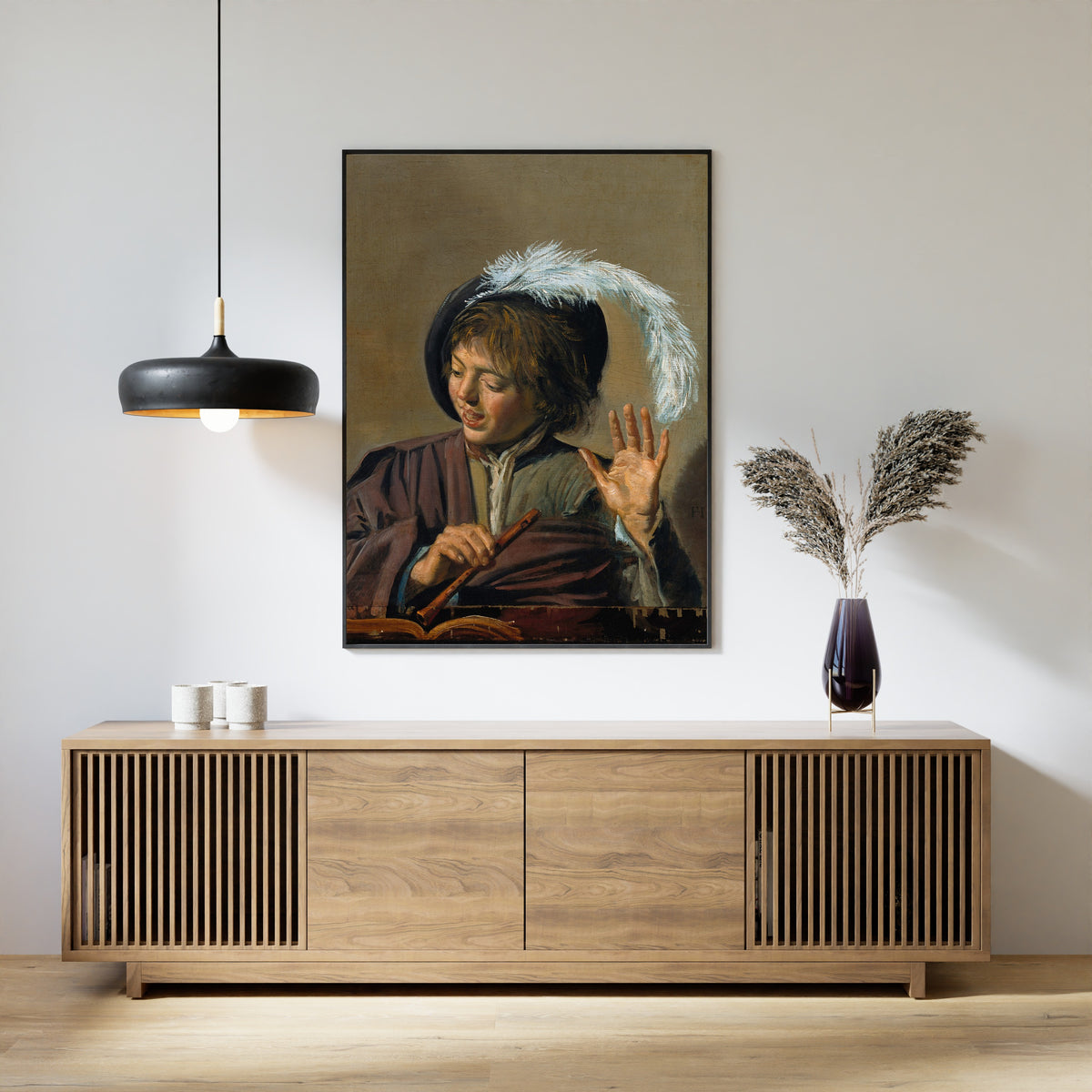Framed art print of Singing Boy with Flute by Frans Hals, above a slatted wood sideboard