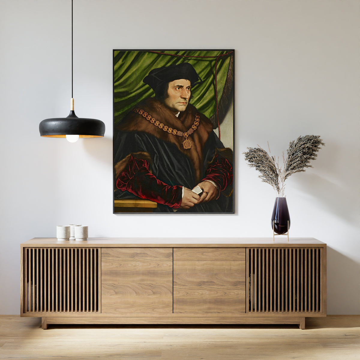 Framed art print of Sir Thomas More by Hans Holbein the Younger, above a slatted wood sideboard
