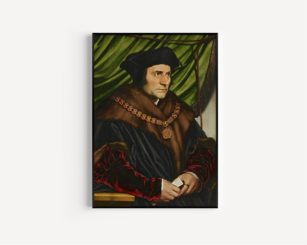Framed art print of Sir Thomas More by Hans Holbein the Younger, in a slim black frame on a plain white wall