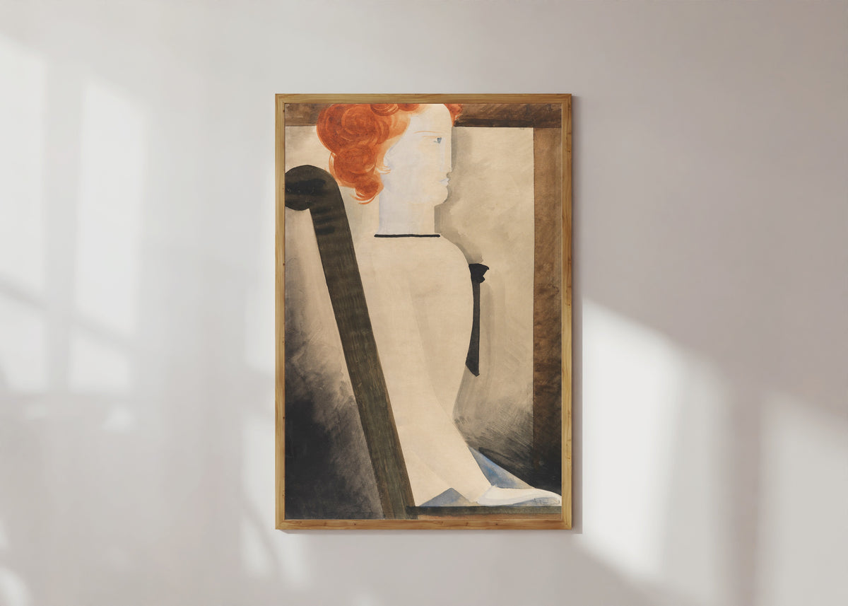 Framed art print of Sitzende by Oskar Schlemmer, in a light wood frame on a sunlit white wall