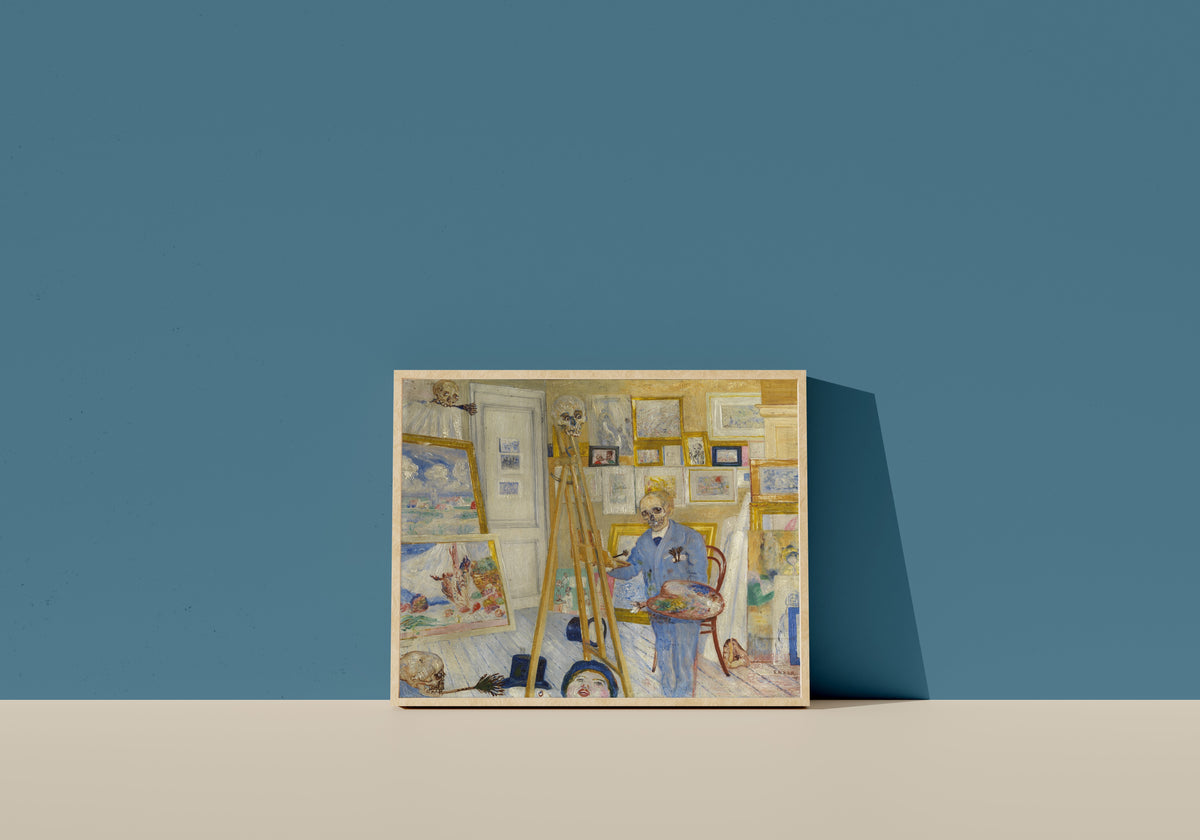 Framed art print of Skeleton Painter in His Studio (Het schilderend geraamte) by James Ensor, in a light wood frame leaning on a blue wall