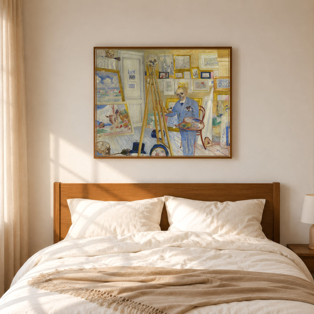 Framed art print of Skeleton Painter in His Studio (Het schilderend geraamte) by James Ensor, in a slim wood frame above a bed in a sunlit bedroom