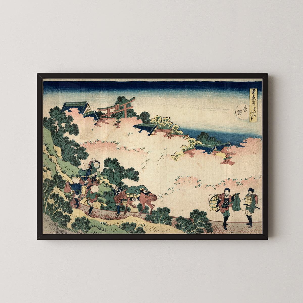 Framed art print of Snow, Moon and Flowers: Yoshino by Katsushika Hokusai, in a black frame on a pale wall