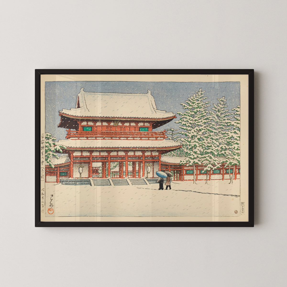 Framed art print of Snow at Heian Shrine, Kyoto by Kawase Hasui, in a black frame on a pale wall