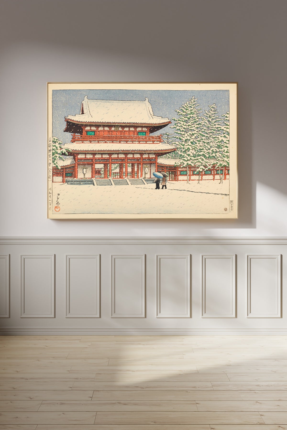 Framed art print of Snow at Heian Shrine, Kyoto by Kawase Hasui, on a panelled wall in afternoon light