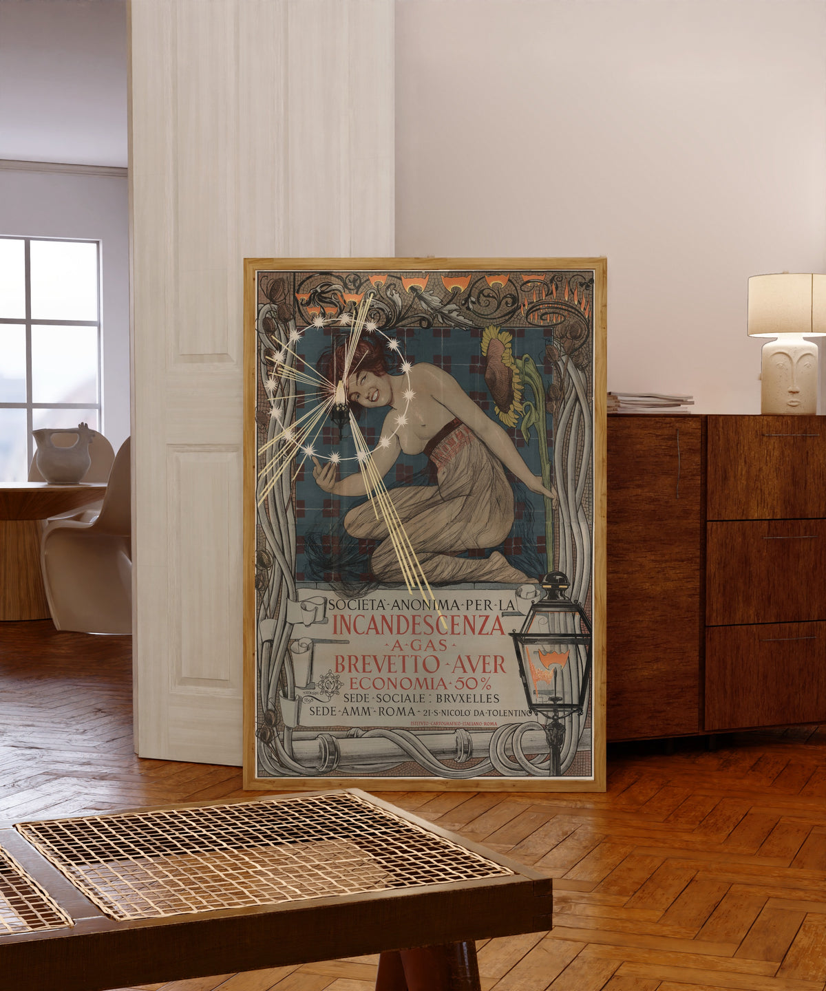 Framed art print of Società Anonima per la Incandescenza a Gas… by Giovanni Maria Mataloni, in a light wood frame leaning in a warm room with a parquet floor