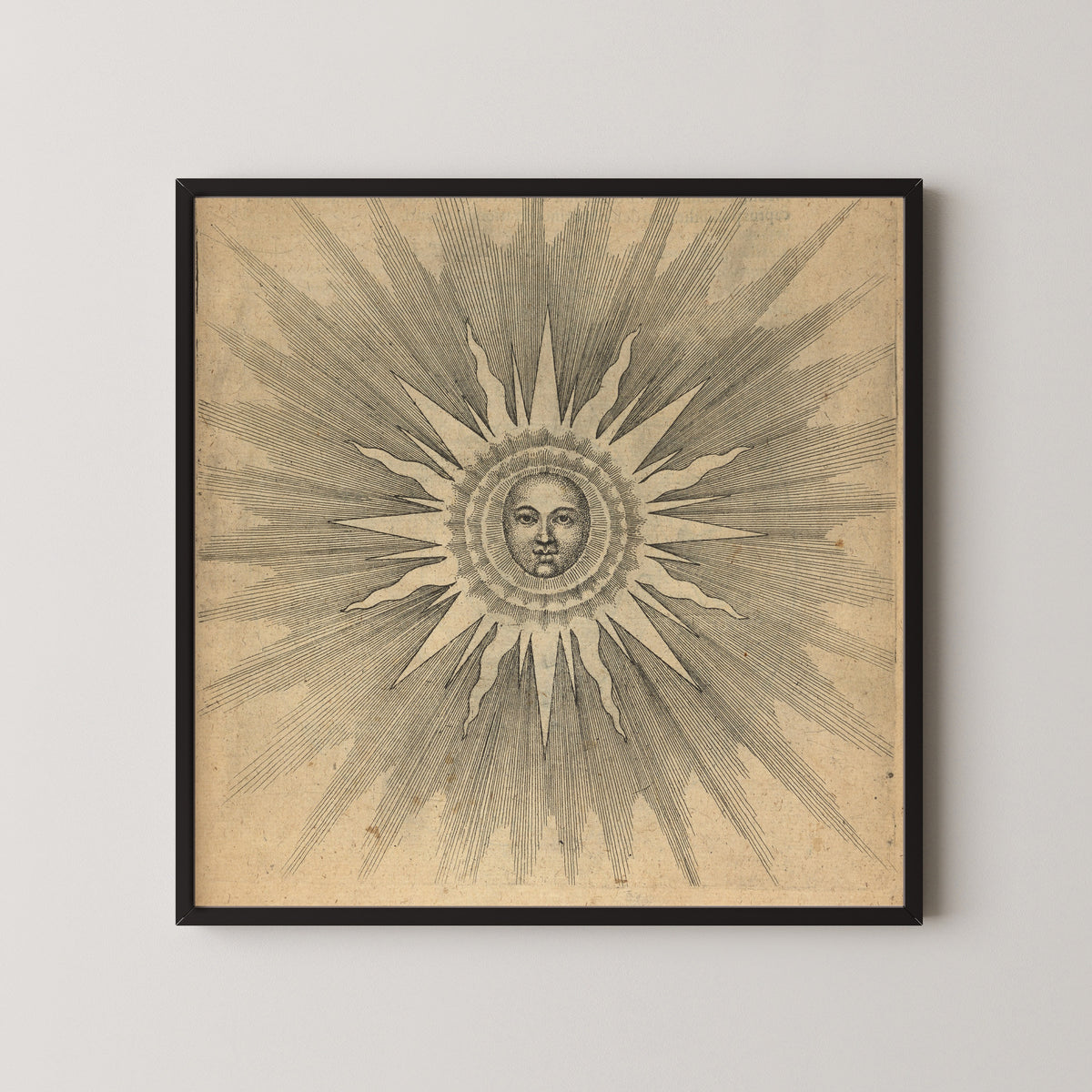Framed art print of Solis: the Sun with a Face (Utriusque Cosmi, p. 19) by Robert Fludd, in a black frame on a pale wall