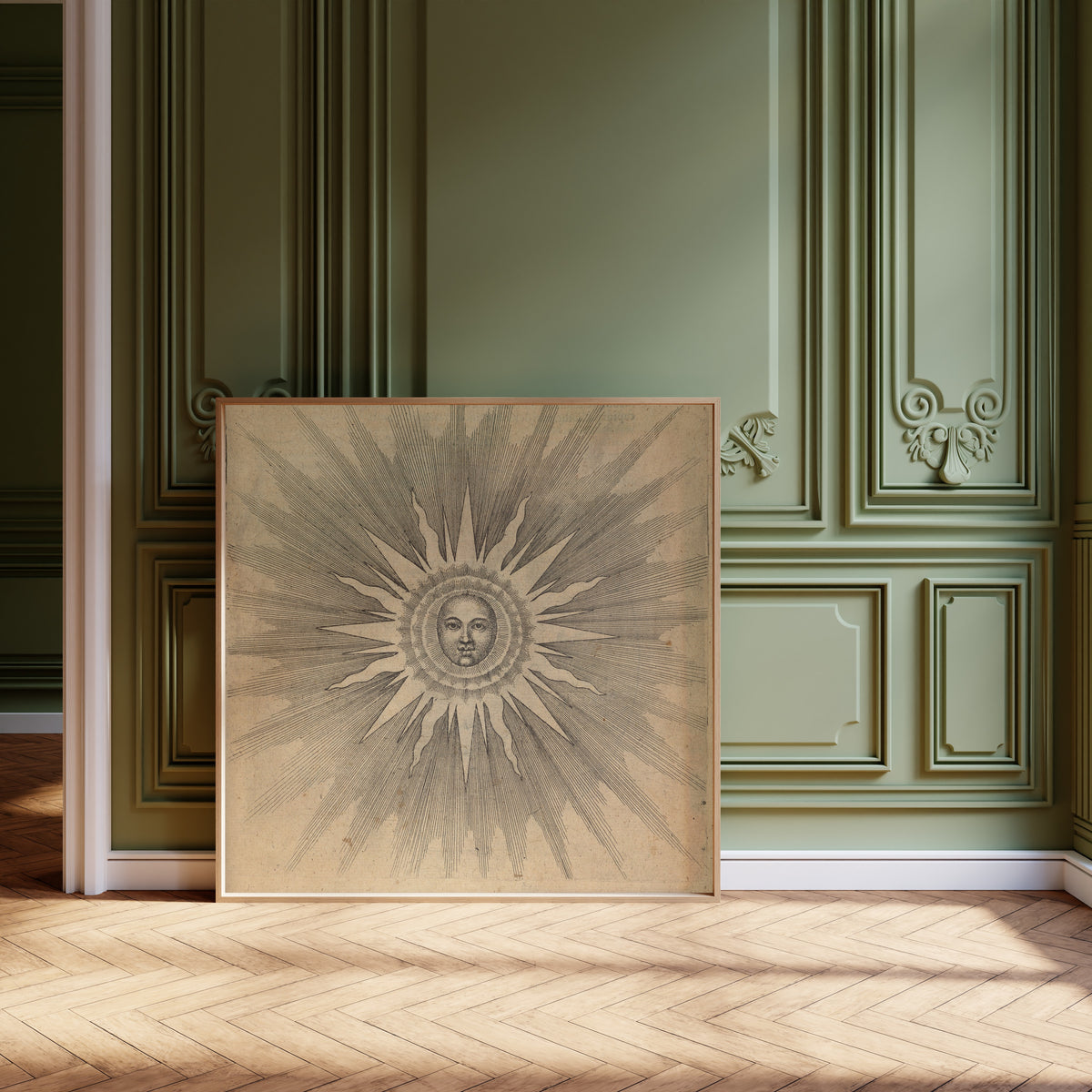 Framed art print of Solis: the Sun with a Face (Utriusque Cosmi, p. 19) by Robert Fludd, leaning against olive-green panelling on a herringbone floor