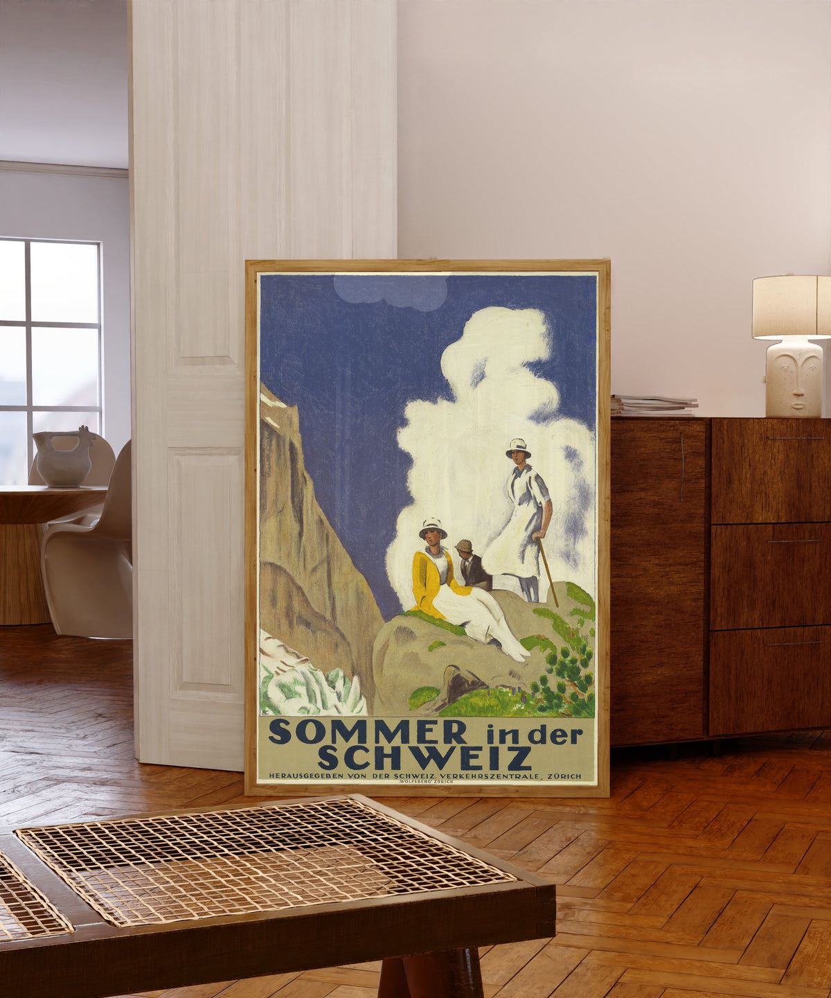 Framed art print of Sommer in der Schweiz by Emil Cardinaux, in a light wood frame leaning in a warm room with a parquet floor