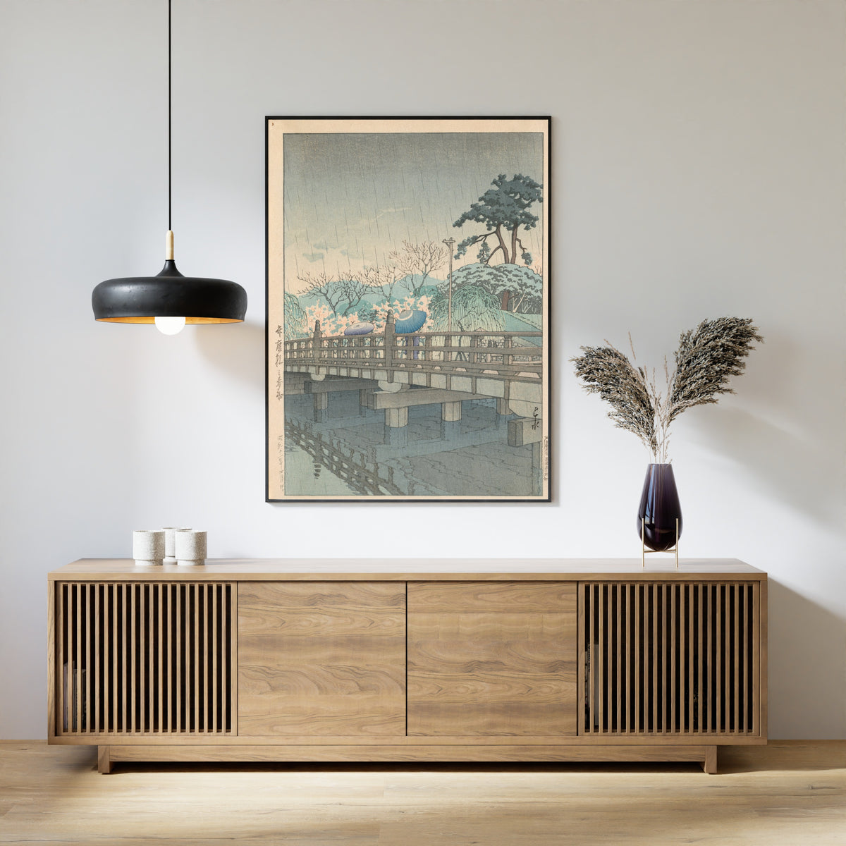 Framed art print of Spring Rain at Benkei Bridge by Kawase Hasui, above a slatted wood sideboard