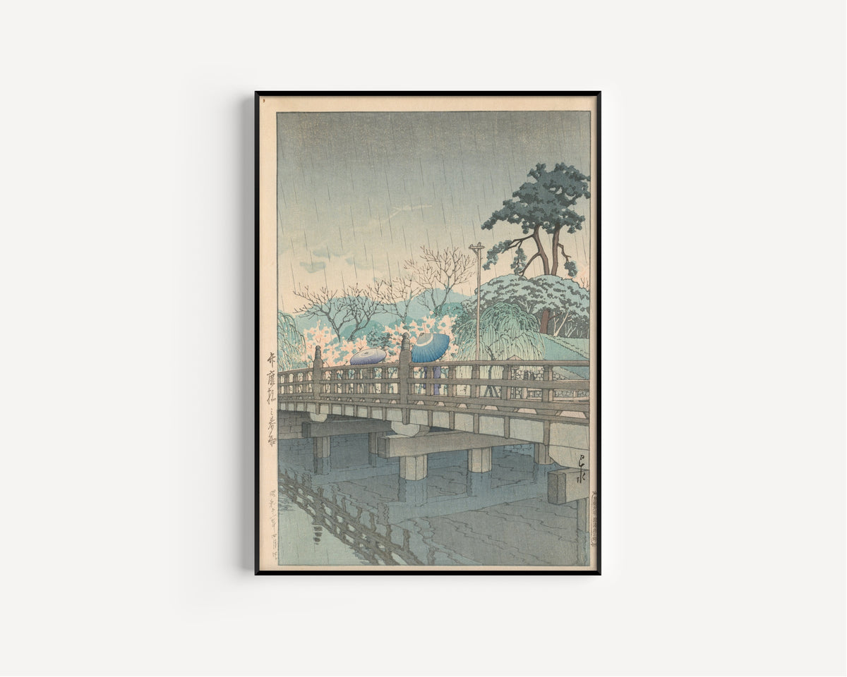 Framed art print of Spring Rain at Benkei Bridge by Kawase Hasui, in a slim black frame on a plain white wall